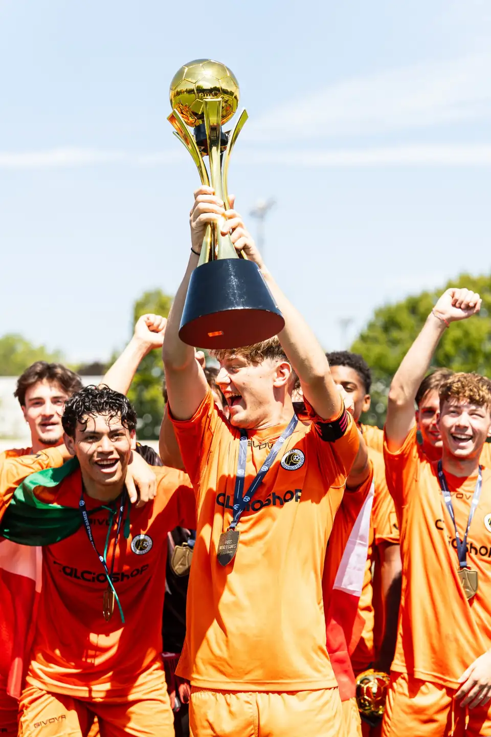 Capitán alzando el trofeo dorado entre su equipo