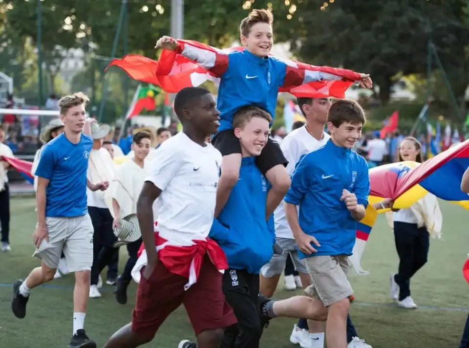 Jeunes joueurs courant avec les drapeaux de leurs pays