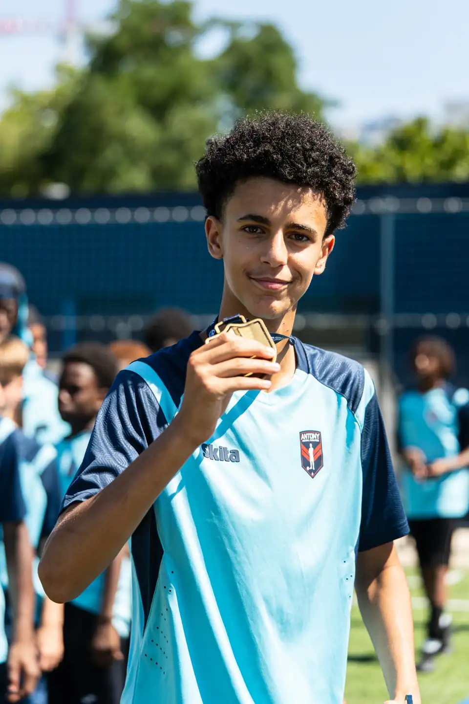 Jeune footballeur montrant sa médaille