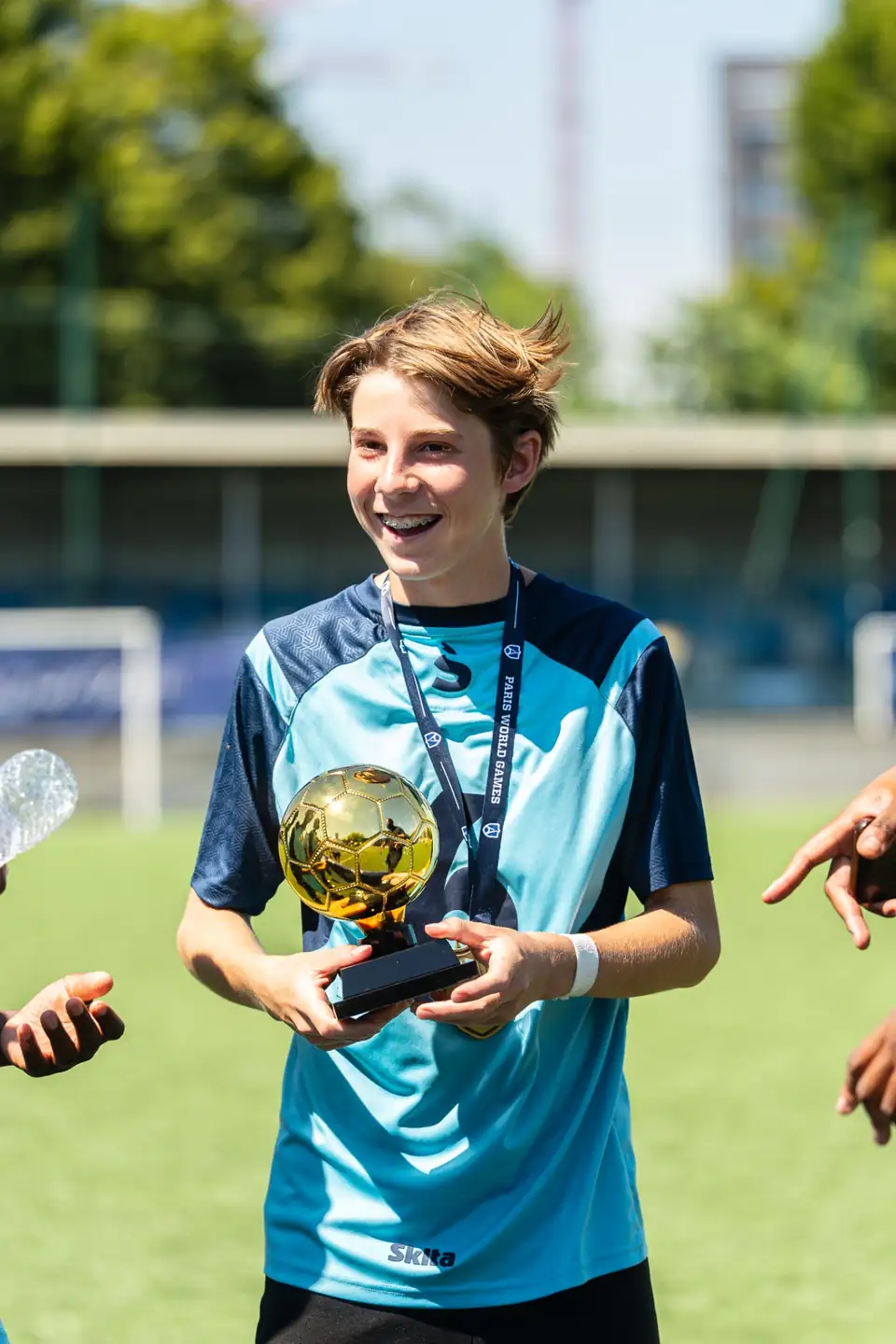 Jeune joueur tenant un trophée individuel en forme de ballon doré