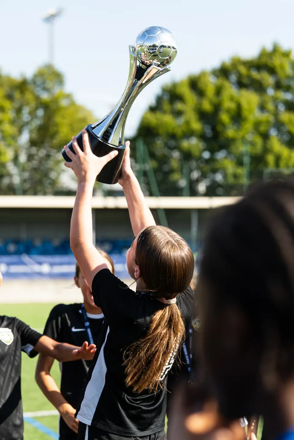 Trophée argenté soulevé à bout de bras après une finale